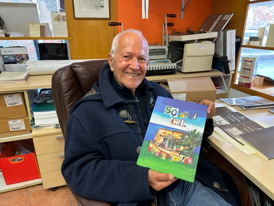 Claudio Turina sorridente con in mano il libro della comunità di Verteneglio